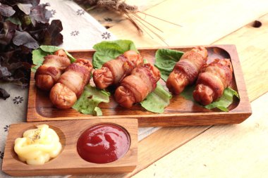 Lezzetli domuz yağında sarılı ızgara sosis.