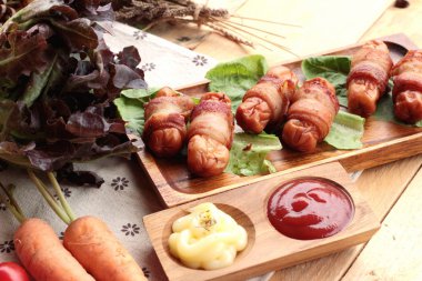 Lezzetli domuz yağında sarılı ızgara sosis.