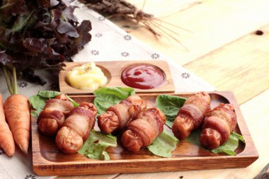 Lezzetli domuz yağında sarılı ızgara sosis.