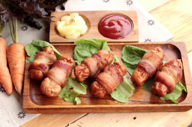 Lezzetli domuz yağında sarılı ızgara sosis.