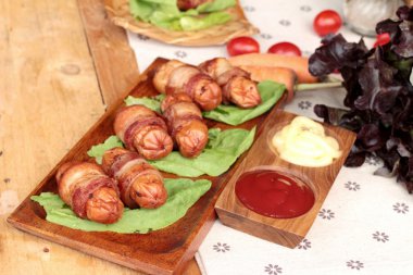 Lezzetli domuz yağında sarılı ızgara sosis.