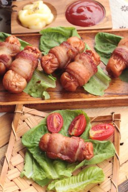 Lezzetli domuz yağında sarılı ızgara sosis.