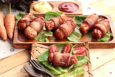 Lezzetli domuz yağında sarılı ızgara sosis.