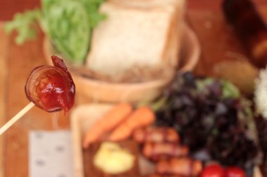 Lezzetli domuz yağında sarılı ızgara sosis.