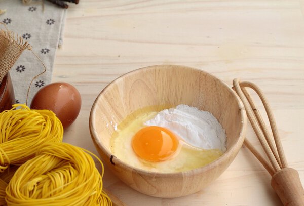 Making yellow noodle with egg and wheat flour.