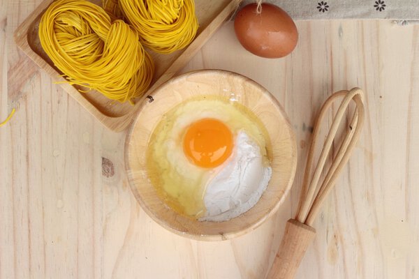 Making yellow noodle with egg and wheat flour.