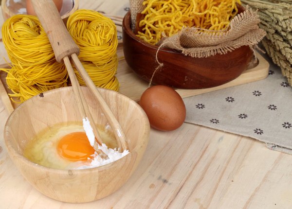 Making yellow noodle with egg and wheat flour.