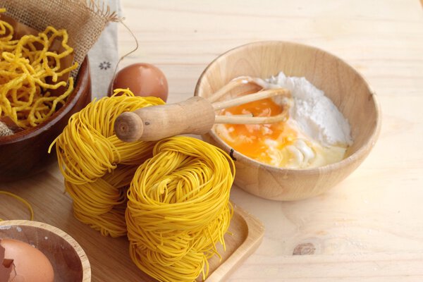 Making yellow noodle with egg and wheat flour.