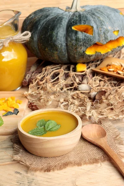 Halloween pumpkins and pumpkin soup on wood background. — Stock Photo, Image