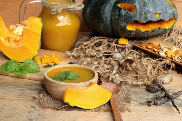 Halloween pumpkins and pumpkin soup on wood background. — Stock Photo, Image