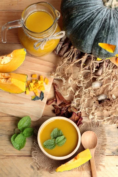 Halloween pumpkins and pumpkin soup on wood background. — Stock Photo, Image