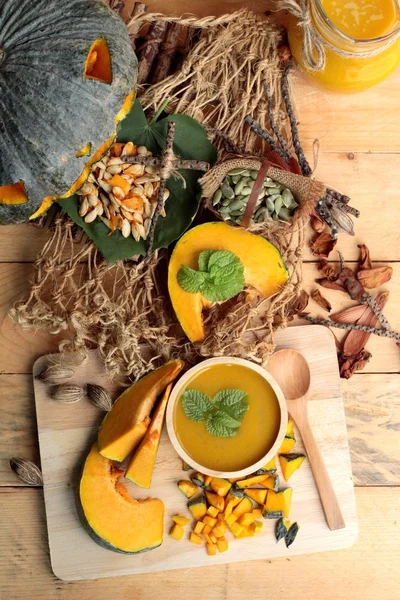 Halloween pumpkins and pumpkin soup on wood background. — Stock Photo, Image