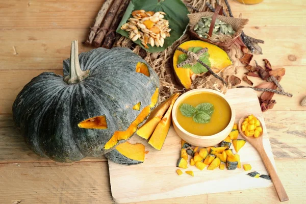 Dynie Halloween i zupa dyniowa na tle drewna. — Zdjęcie stockowe