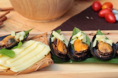 Midye fırında, peynir serpin lezzetlidir.