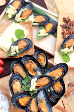 Midye fırında, peynir serpin lezzetlidir.