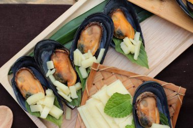 Midye fırında, peynir serpin lezzetlidir.