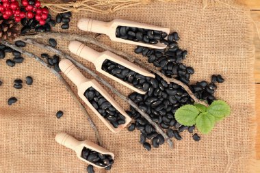 Ahşap arka plan üzerinde siyah kuru fasulye.