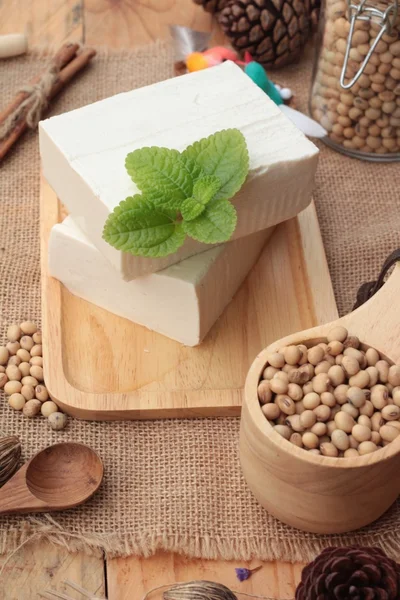 Tofu e soja sobre fundo de madeira . — Fotografia de Stock