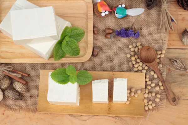 Tofu e soja sobre fundo de madeira . — Fotografia de Stock