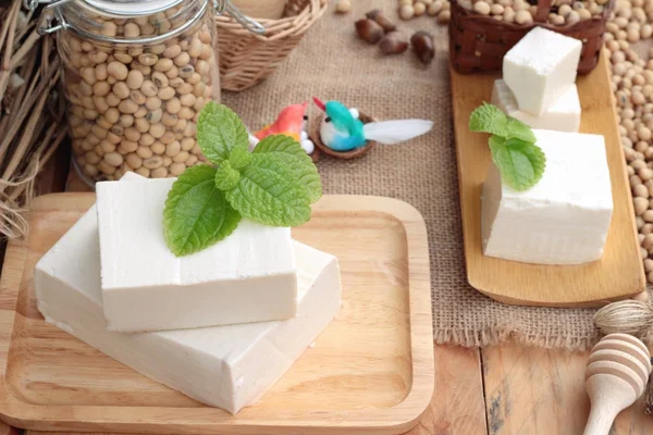 Tofu e soja sobre fundo de madeira . — Fotografia de Stock