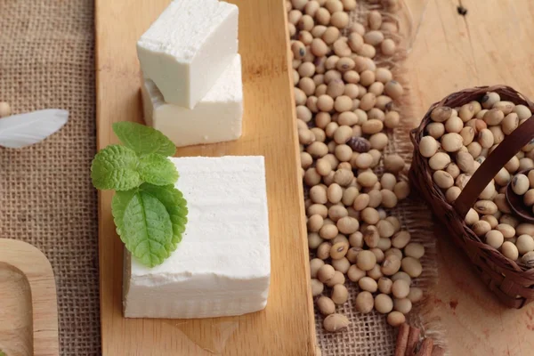 Tofu e soja sobre fundo de madeira . — Fotografia de Stock