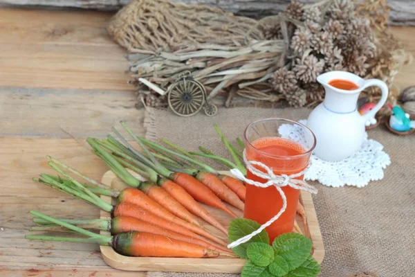 Sumo de cenoura espremido fresco e cenouras frescas . — Fotografia de Stock