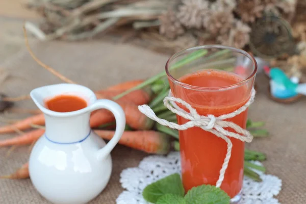 Succo di carota spremuto fresco e carote fresche . — Foto Stock