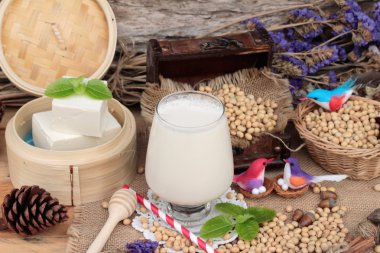 Soya sütü ve soya fasulyesi ahşap arka plan üzerinde.