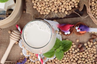 Soya sütü ve soya fasulyesi ahşap arka plan üzerinde.