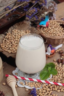 Soya sütü ve soya fasulyesi ahşap arka plan üzerinde.