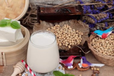 Soya sütü ve soya fasulyesi ahşap arka plan üzerinde.
