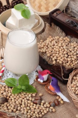 Soya sütü ve soya fasulyesi ahşap arka plan üzerinde.
