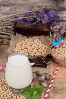 Soya sütü ve soya fasulyesi ahşap arka plan üzerinde.