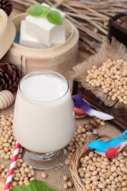 Soya sütü ve soya fasulyesi ahşap arka plan üzerinde.