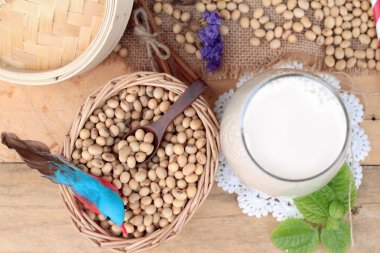 Soya sütü ve soya fasulyesi ahşap arka plan üzerinde.