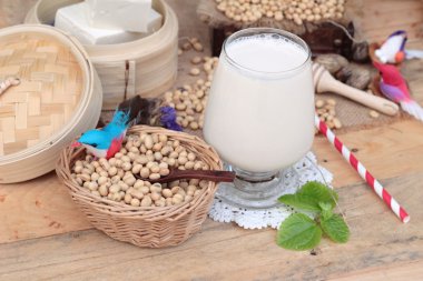Soya sütü ve soya fasulyesi ahşap arka plan üzerinde.