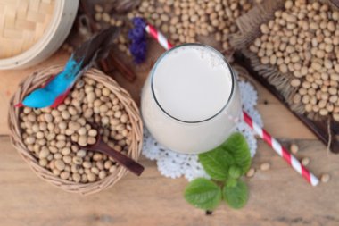 Soya sütü ve soya fasulyesi ahşap arka plan üzerinde.