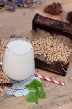 Soya sütü ve soya fasulyesi ahşap arka plan üzerinde.