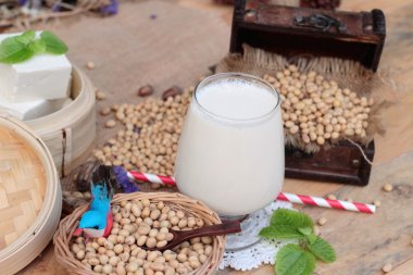 Soya sütü ve soya fasulyesi ahşap arka plan üzerinde.