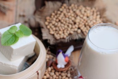 Soya sütü ve soya fasulyesi ahşap arka plan üzerinde.