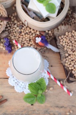Soya sütü ve soya fasulyesi ahşap arka plan üzerinde.