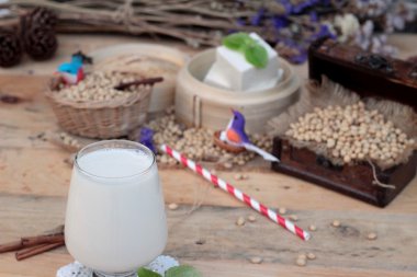 Soya sütü ve soya fasulyesi ahşap arka plan üzerinde.