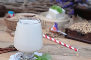 Soya sütü ve soya fasulyesi ahşap arka plan üzerinde.