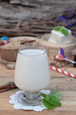 Soya sütü ve soya fasulyesi ahşap arka plan üzerinde.