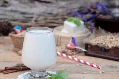 Soya sütü ve soya fasulyesi ahşap arka plan üzerinde.