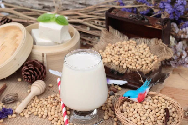 Soy mjölk och sojabönor på trä bakgrund. — Stockfoto