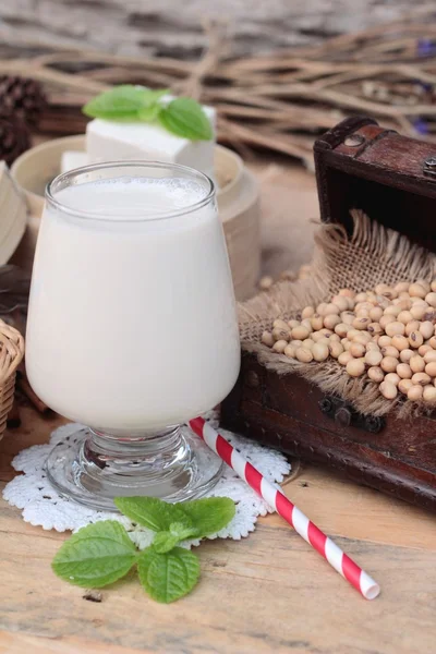 Soy mjölk och sojabönor på trä bakgrund. — Stockfoto