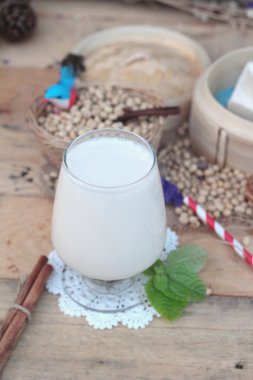 Soya sütü ve soya fasulyesi ahşap arka plan üzerinde.