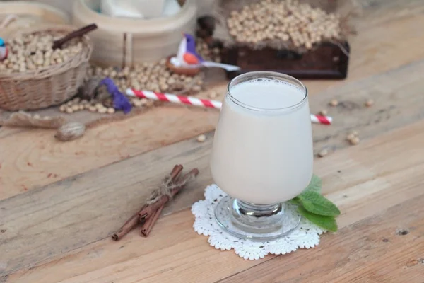 Soya sütü ve soya fasulyesi ahşap arka plan üzerinde.