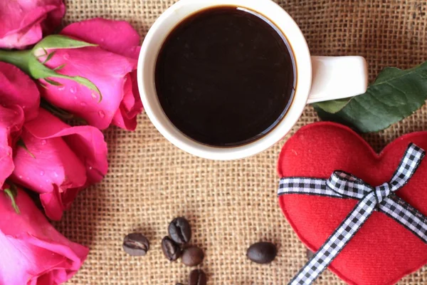 Kaffee mit Kaffeebohnen und roten Herzen. — Stockfoto